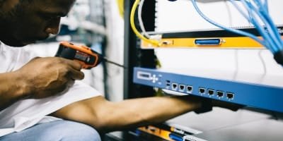 Technician performing hard services maintenance on server equipment.